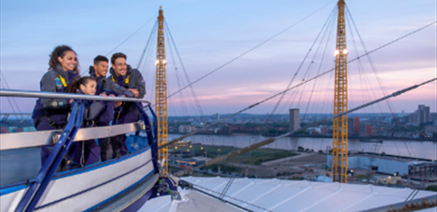 A family enjoy the view from Up at The O2 at sunset.