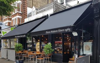 Pizza Express Blackheath, showing a blacked out restaurant with outdoor and indoor seating.