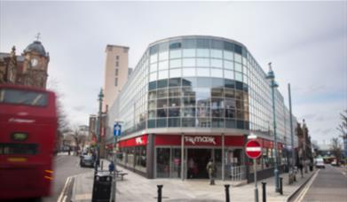 Outside TK Maxx in Woolwich, showing a big and
modern glass building.