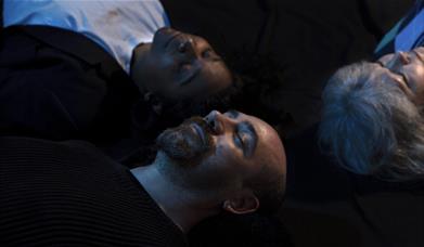 Three people lying down in the darkness at Dreamachine in Woolwich.