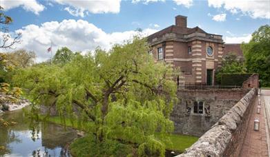 Eltham Palace and Gardens and moat with blue sky