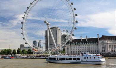 A Viscount Cruises boat sailing past the London Eye.