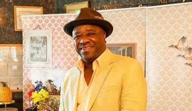 Man in a yellow suit smiling