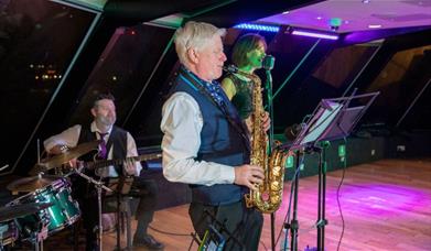Jazz Band performance taking place onboard City Cruises Jazz Dinner Cruise with guest dancing on the dance floor.