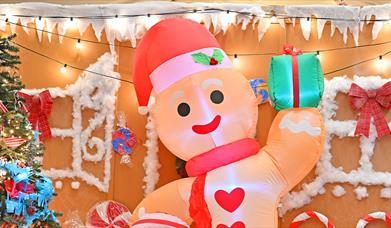 An inflatable gingerbread man in Woolwich works surrounded by a festive Christmas setting.