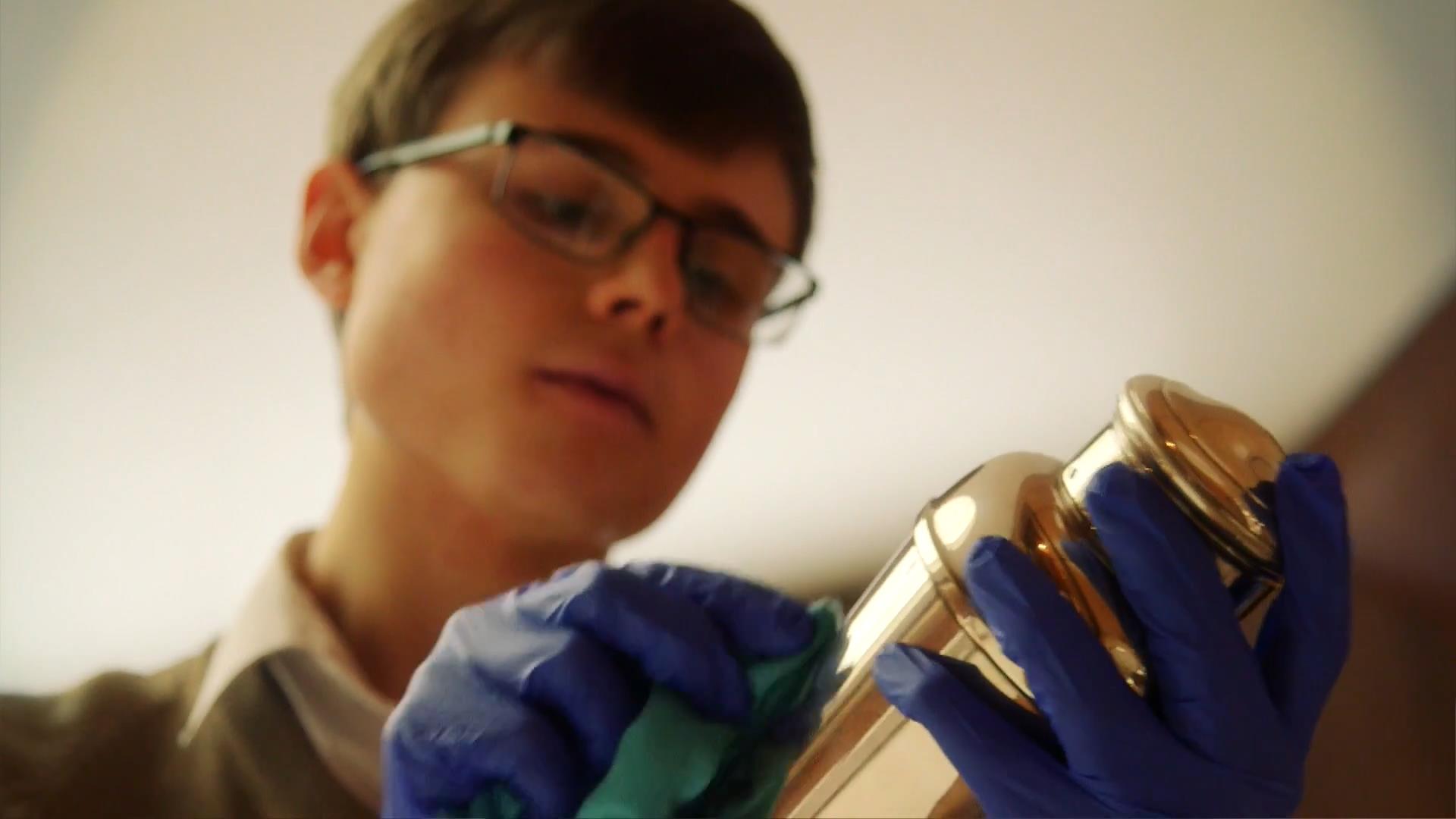 An employee polishes an item at Eltham Palace.