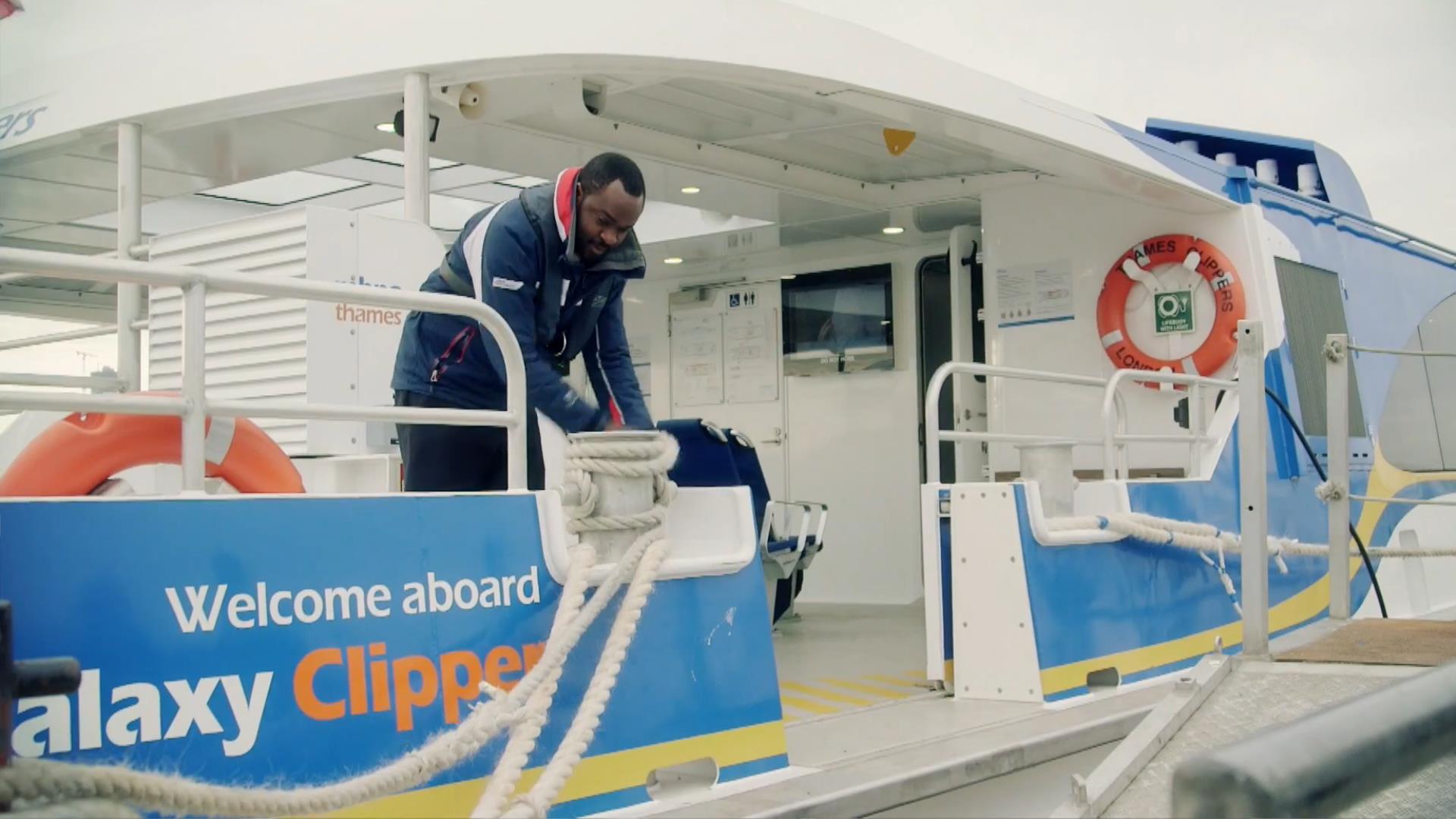 An employee at Uber Boat by Thames Clippers ties the ropes on the boat.