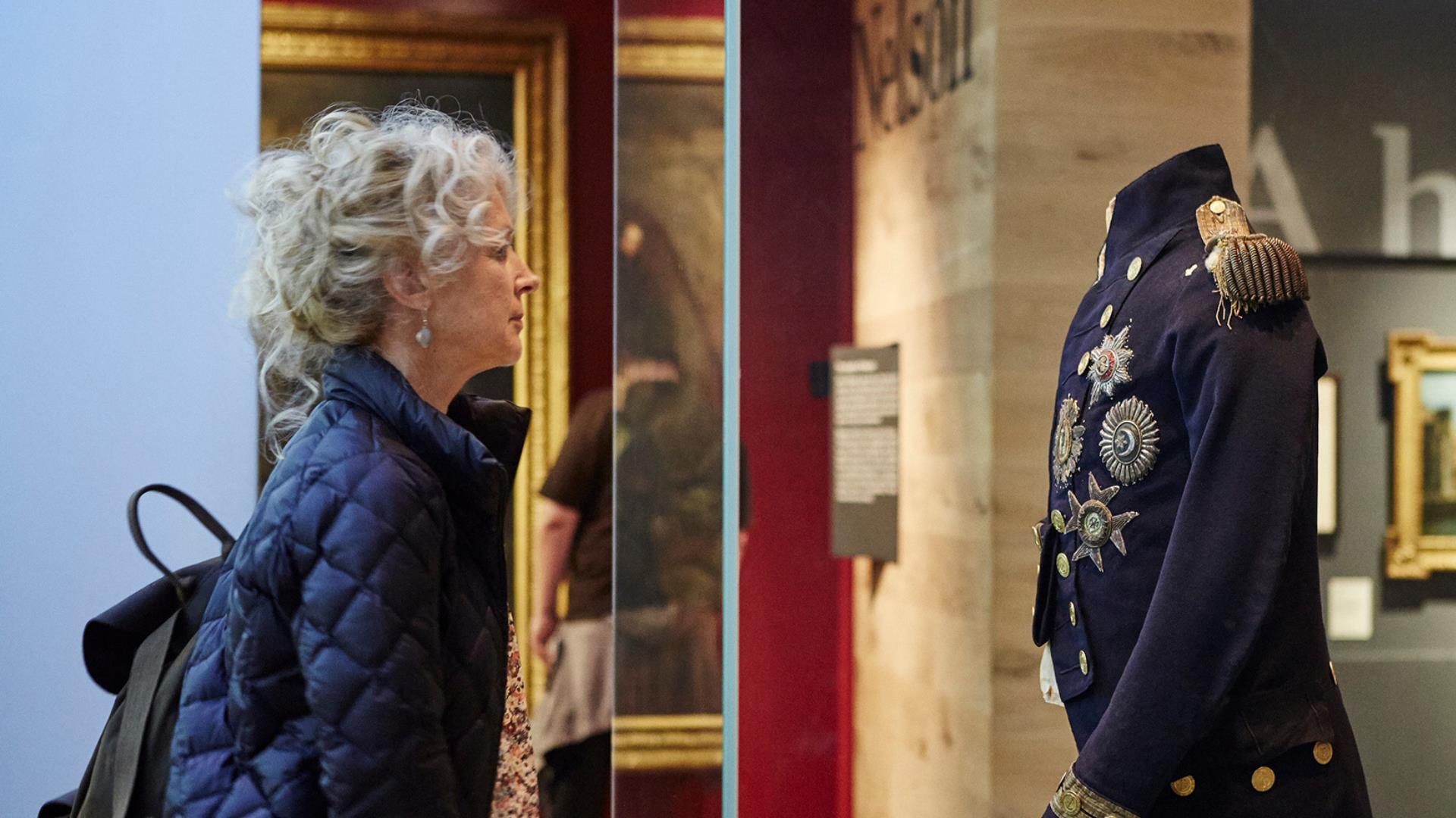 A woman looks at Lord Nelson's jacket worn at the Battle of Trafalgar at the National Maritime Museum, Greenwich.