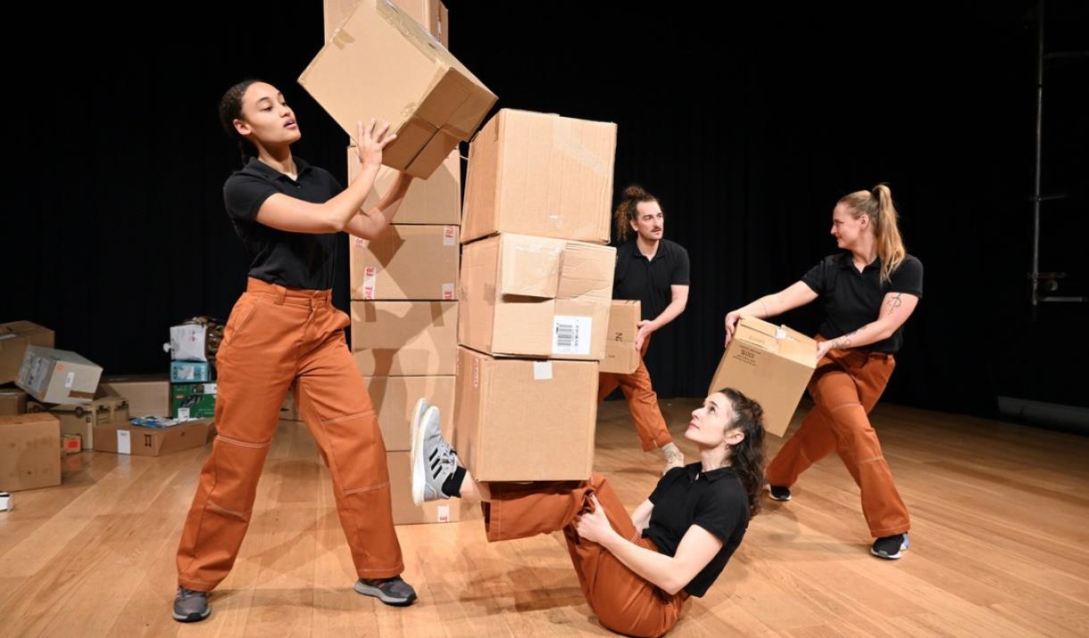 Group of people dancing with and around cardboard boxes