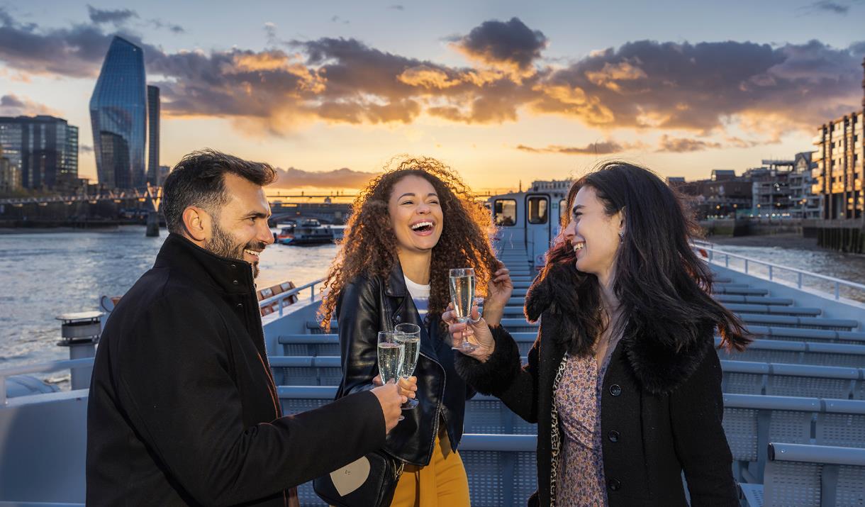 People enjoy a drink on City Cruises at sunset