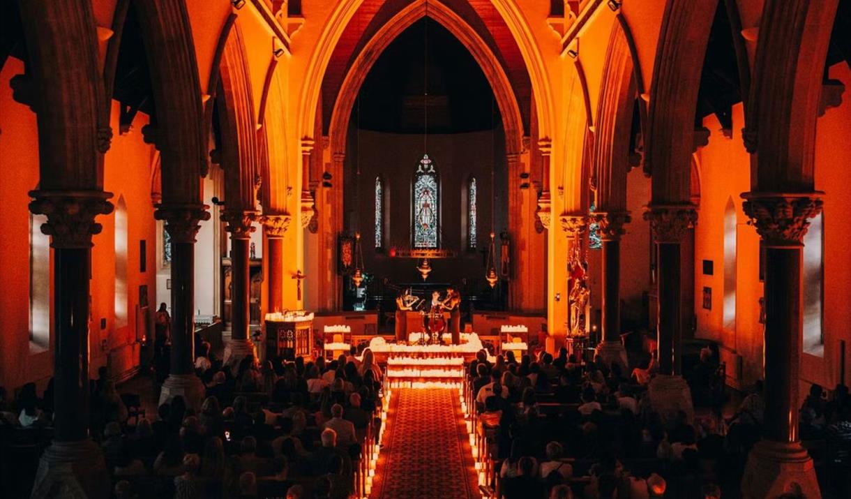An intimate candlelit setting at St Alfege Church, Greenwich, featuring a captivating live string trio performance 🎻