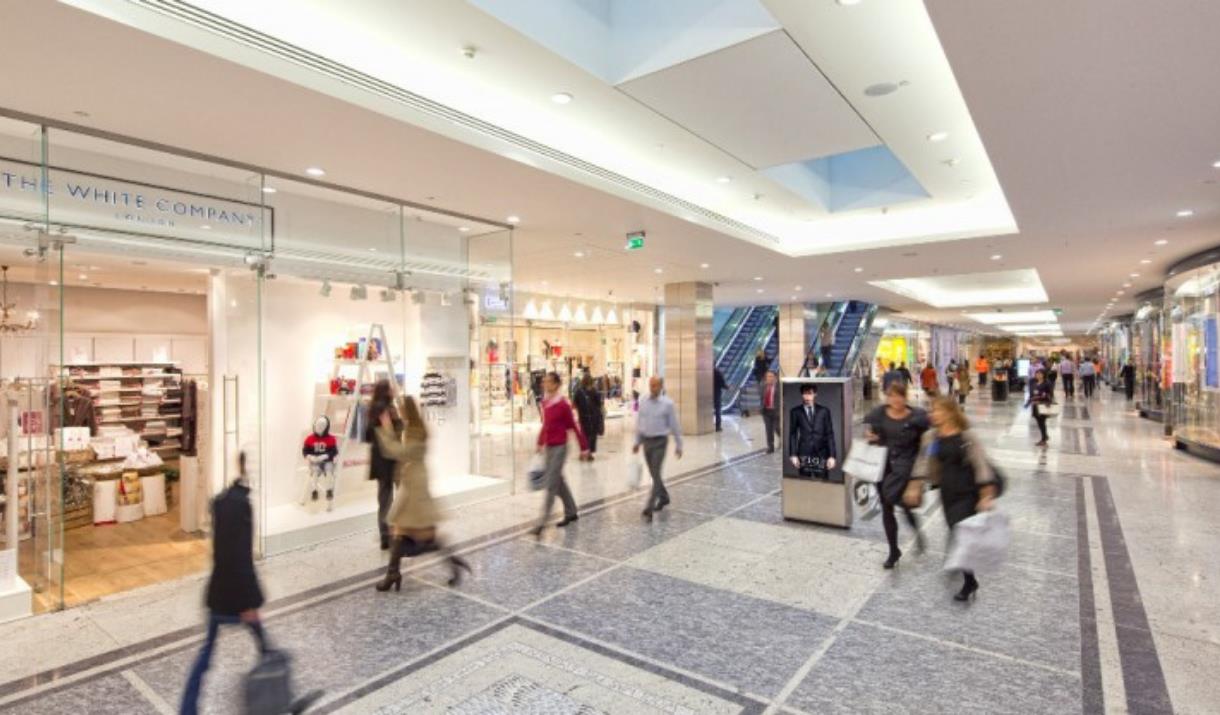 A photo taken inside of the Canary Wharf Shopping centre. Showing a well lighted and visually stunning shopping centre, with lots of shops to visit.