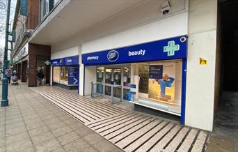 Outside Boots in Woolwich, showing a blue and white shop front.