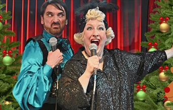 two people singing karaoke in Woolwich with Christmas trees in the background