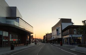 Eltham High Street on a lovely sunset evening, showing a long road filled with shops, entertainment and more.