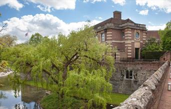 Eltham Palace and Gardens and moat with blue sky