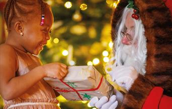 Little girl receiving a gift from Santa Claus