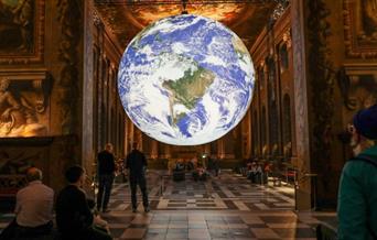 Luke Jerram’s awe-inspiring art installation Gaia which is an internally-lit globe sculpture is displayed in the centre of the Painted Hall.