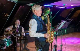 Jazz Band performance taking place onboard City Cruises Jazz Dinner Cruise with guest dancing on the dance floor.