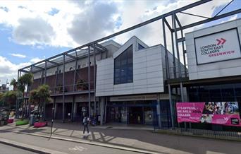 Outside view of London South East Colleges Greenwich campus with pink banner outside on the right side railing.