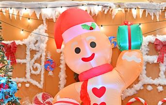 An inflatable gingerbread man in Woolwich works surrounded by a festive Christmas setting.