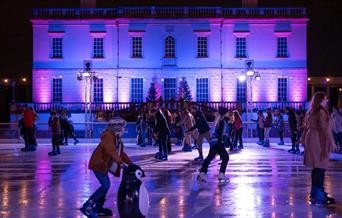 People skating at night at the Queen's House Ice Rink