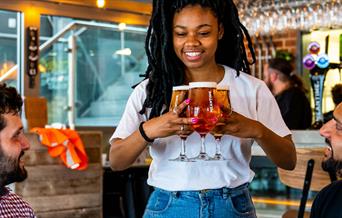 A waitress brings a round of drinks to the table at the Meantime Tasting Rooms.