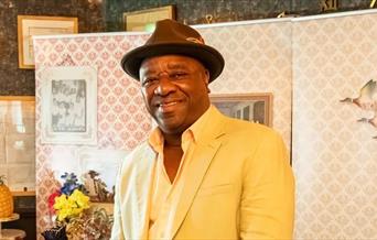 Man in a yellow suit smiling