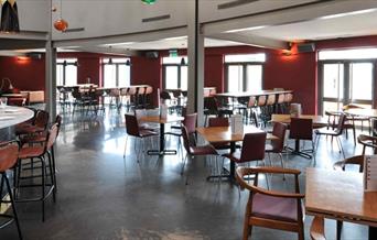 Interior image of Zerodegrees Microbrewery Restaurant with a bar and high chairs on the left side and more seating on the other side.