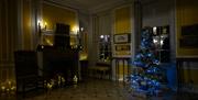 A capture of the Yellow Room in The Fan Museum, decorated with electric candles, and featuring the Musuem Christmas Tree.