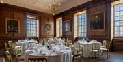White banqueting rounds on wooden floor and pictured walls at the Admiral's House, Old Royal Naval College