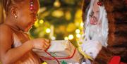 Little girl receiving a gift from Santa Claus