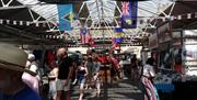 Traders and visitors moving inside Greenwich Market.