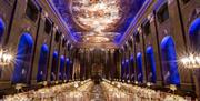 white banqueting round tables setup in the Painted Hall for formal dinner with blue lighting
