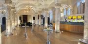 Poseur tables and bar between columns for a reception at the Queen Mary Undercroft, Old Royal Naval College