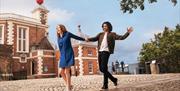 A couple hold hands on the Meridian Line at the Royal Observatory