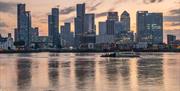 Speeding down the Thames past Canary Wharf on Uber Boat by Thames Clippers.