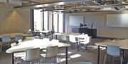 Table and chairs in cabaret style in a meeting room in the University of Greenwich