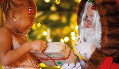 Little girl receiving a gift from Santa Claus