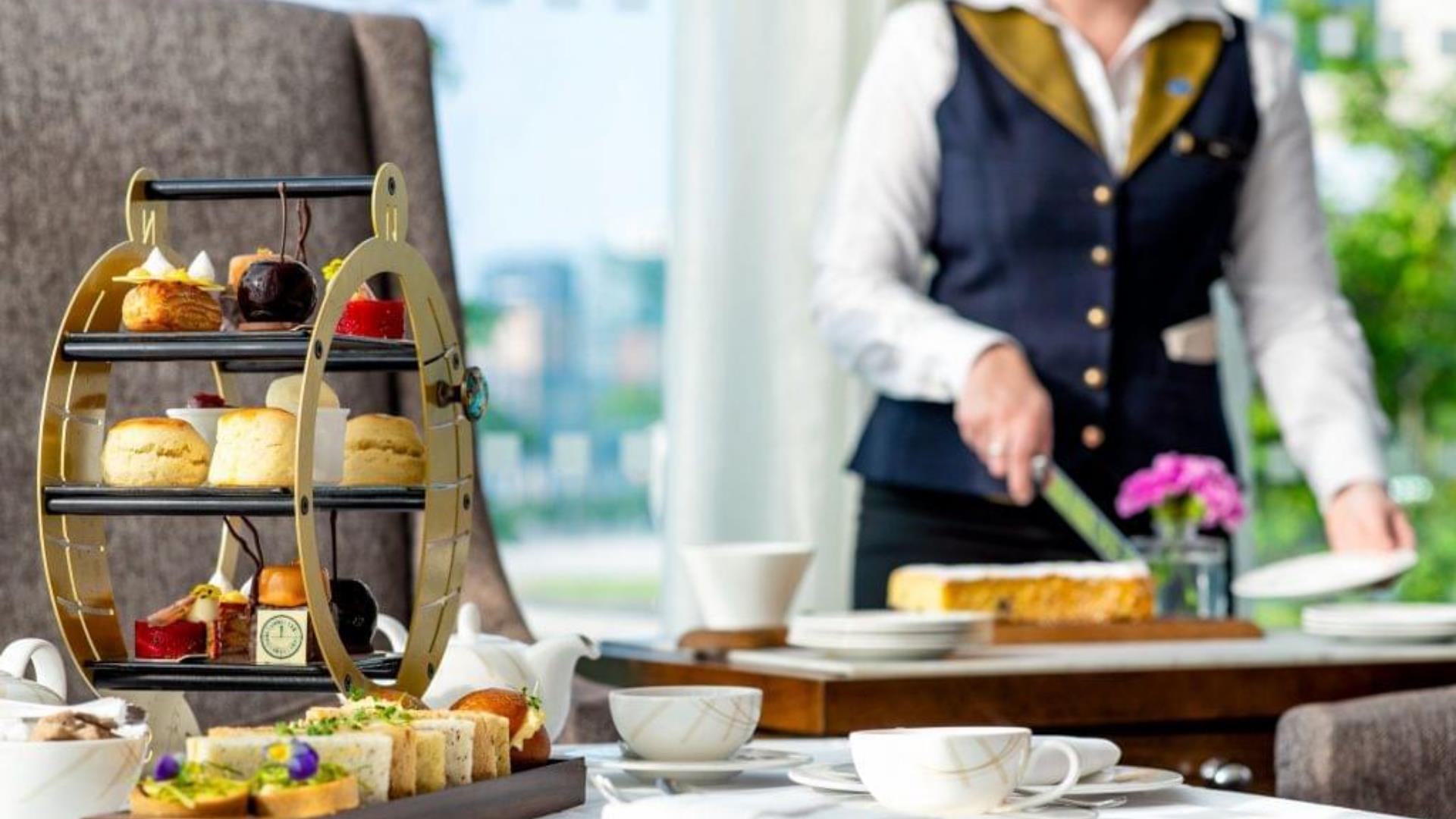 A waiter serves up afternoon tea at the Meridian Lounge, InterContinental London - The O2. Special Offers in Greenwich.