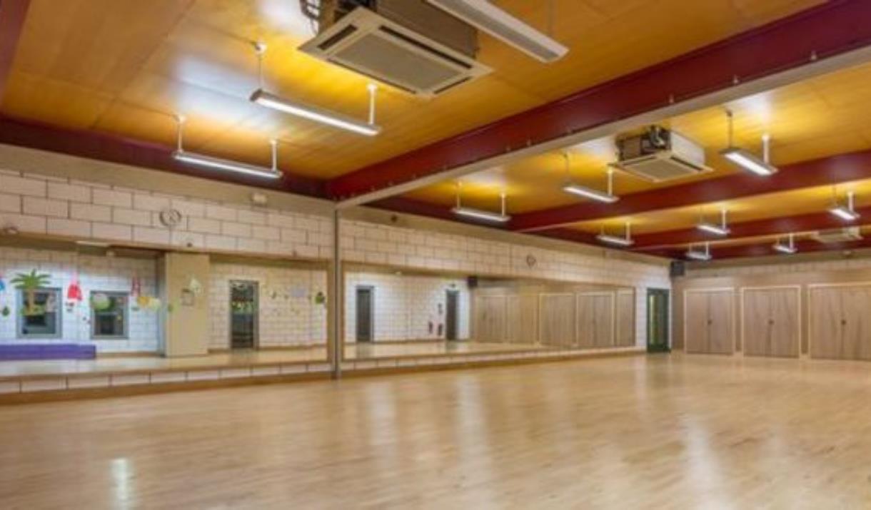 Inside one of Thamesmere Leisure Centre's fitness halls, showing a brown room with mirrors, good lighting and air conditioning.