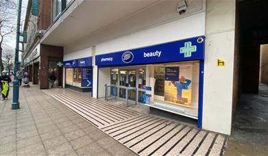 Outside Boots in Woolwich, showing a blue and white shop front.