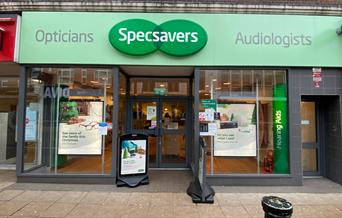 Outside Specsavers, showing a pale green shop front with a lovely inside area.