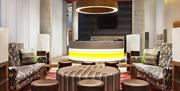 A comfy lounge area with sofas and stools at Aloft London Excel in London's Docklands.