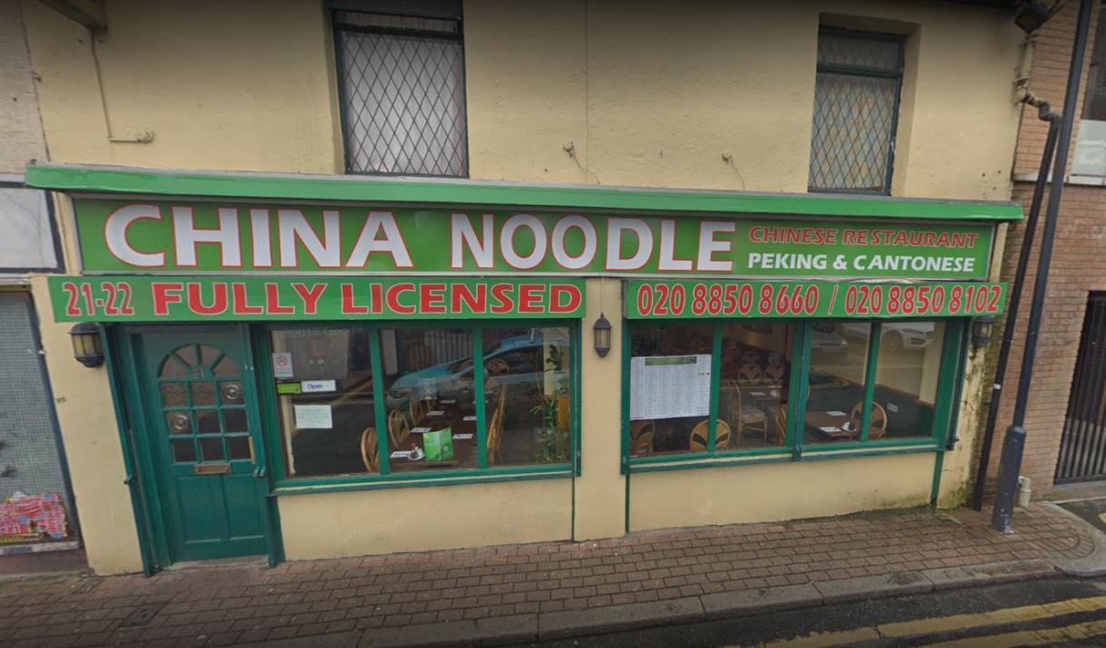 The outside of China Noodle Eltham, a green and red designed restaurant.