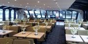 Dining tables and chairs in the interior of a City Cruises boat