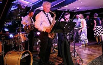 Jazz Band performance taking place onboard City Cruises Jazz Dinner Cruise with guest dancing on the dance floor.