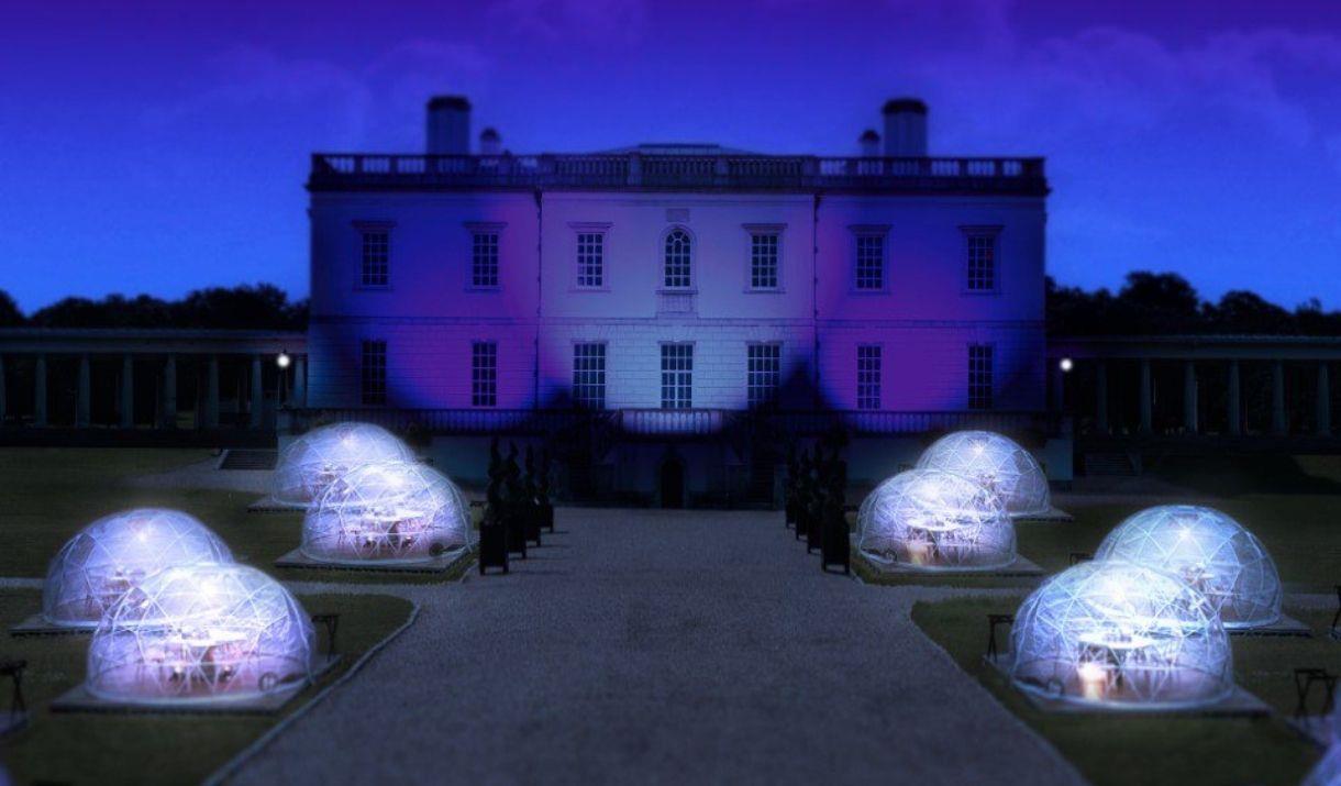 Night view of the Queen's House with eight Dining Domes set on the grounds in front of the art gallery.