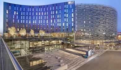 Main view of the Aloft London Excel exterior with deep blue and purple shades during evening time