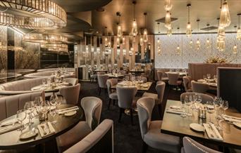 Interior image of Gaucho, The O2 fine dining restaurant with lights set on dim lighting and tables elegantly set.